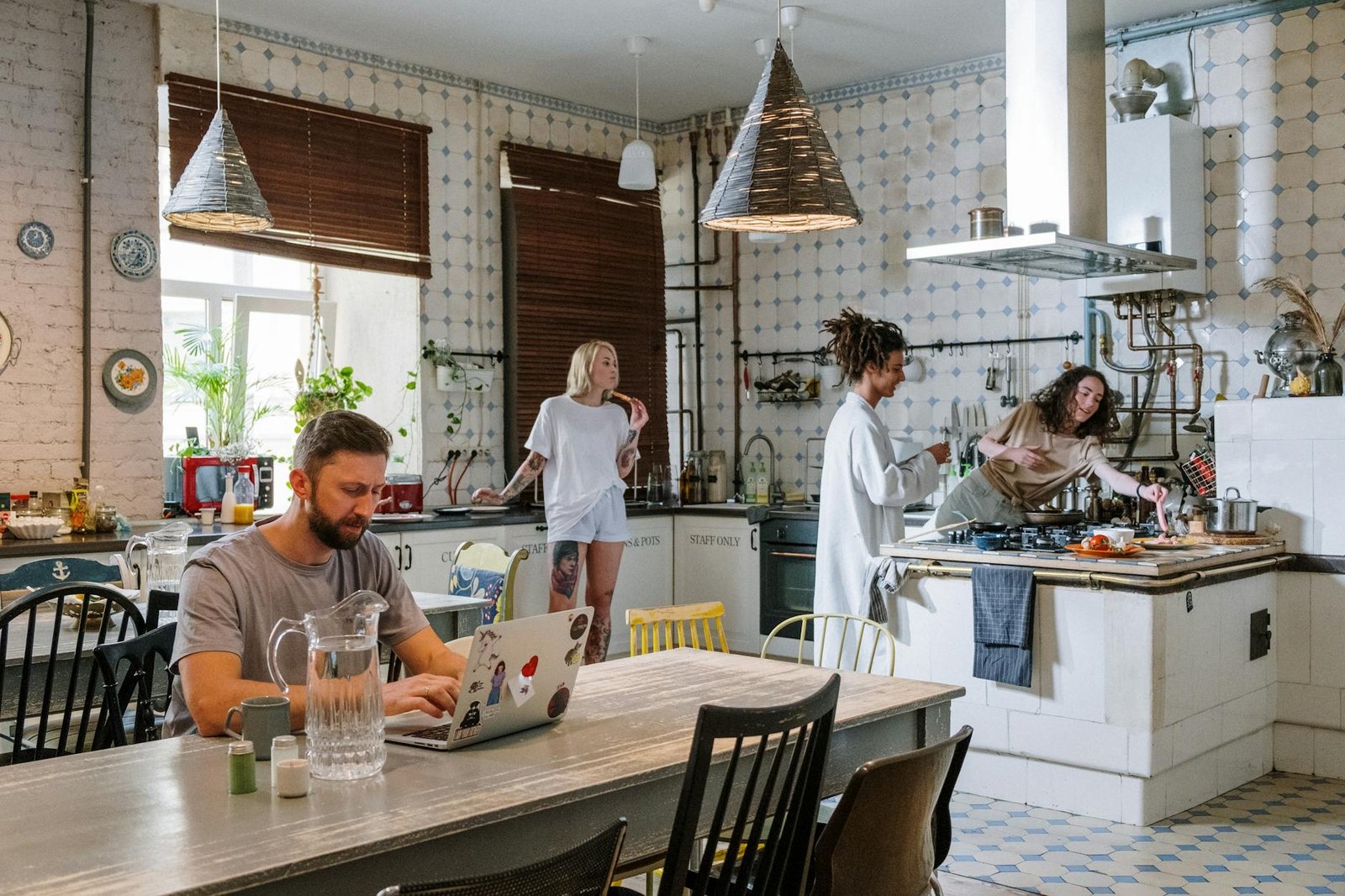 A group of friends cooking and working together in a modern kitchen setting.