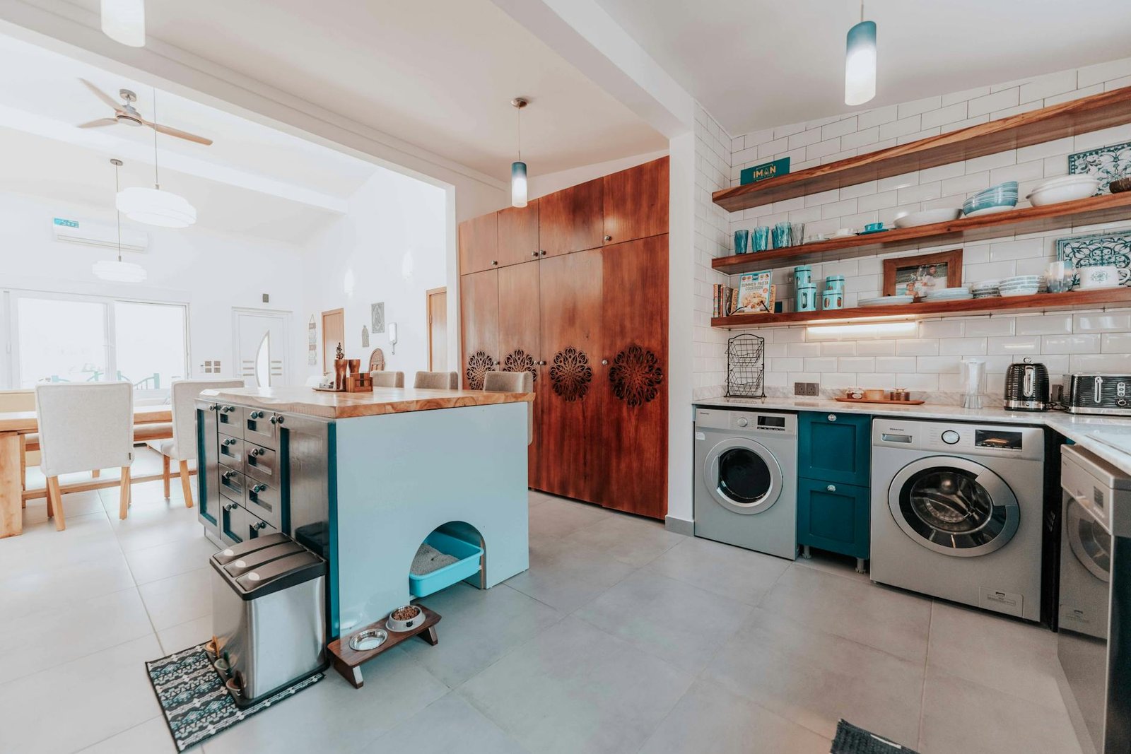 Bright and modern kitchen interior with dining area, featuring open shelving and stylish appliances.