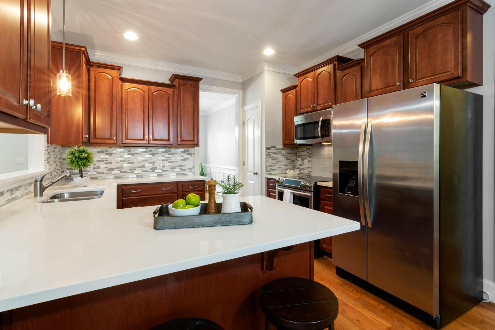 Stylish wooden kitchen featuring stainless steel appliances and a sleek countertop.