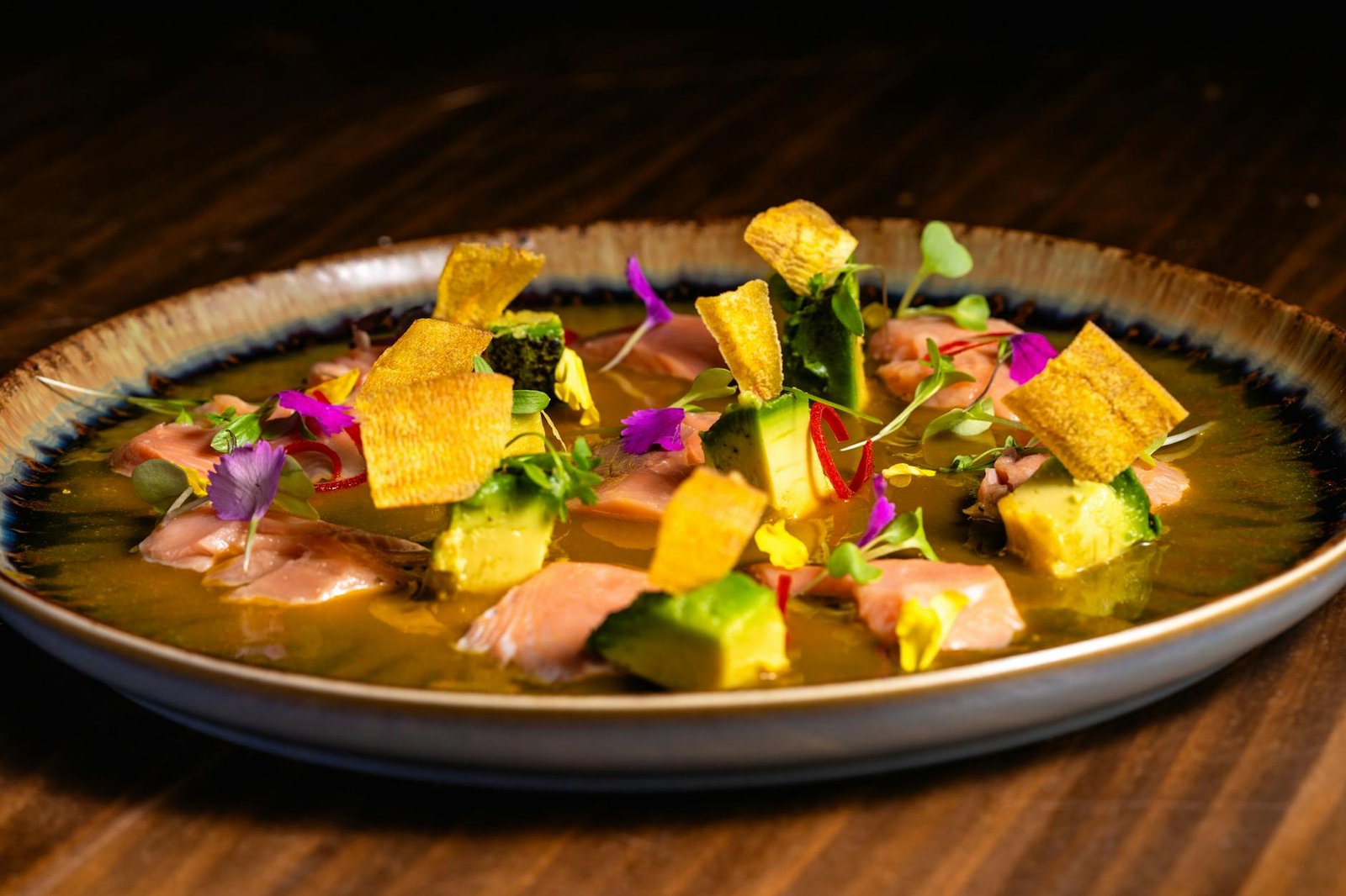 A beautifully plated ceviche with vibrant edible flowers and garnishes, perfect for gourmet dining concepts.