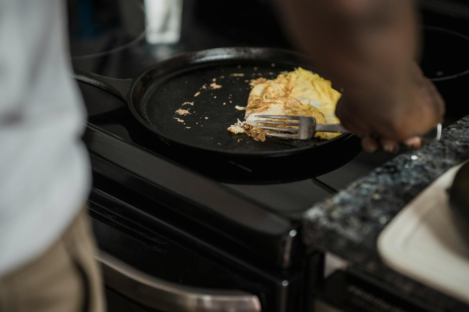 Fixing a Faulty Stove Burner: Step-by-Step Repair Guide 2 Man cooking omelet in a pan on a stove, showcasing a home-cooked meal setting.