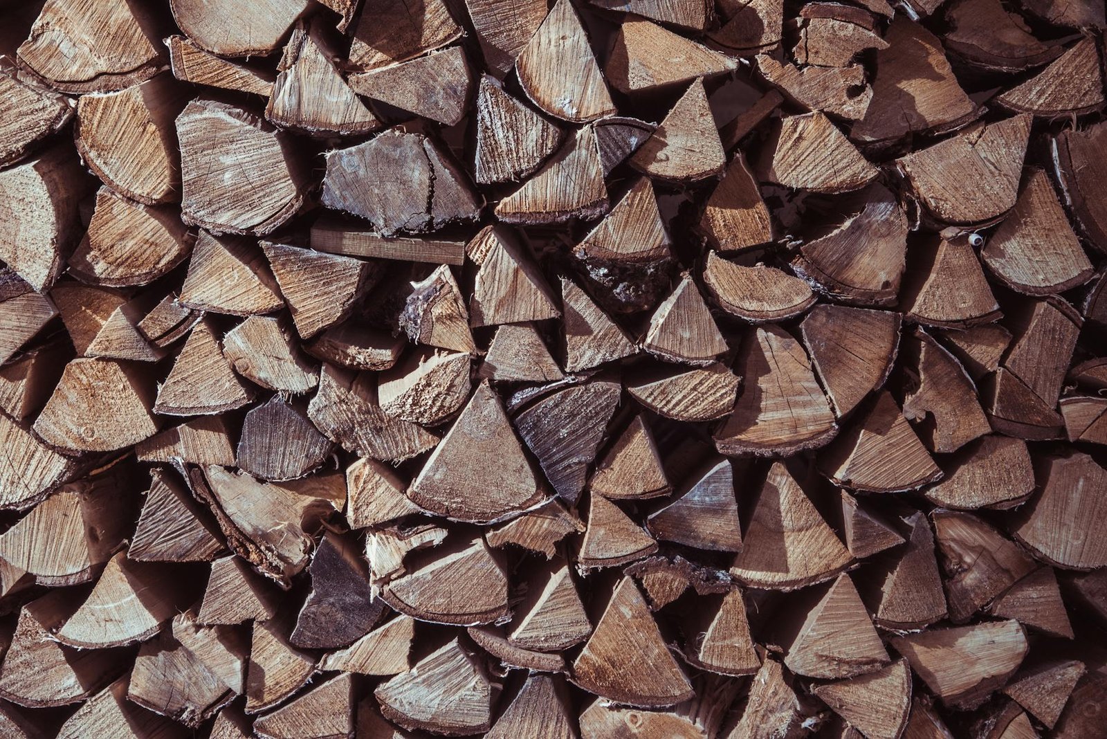 Close-up view of stacked firewood displaying natural textures and earthy tones.