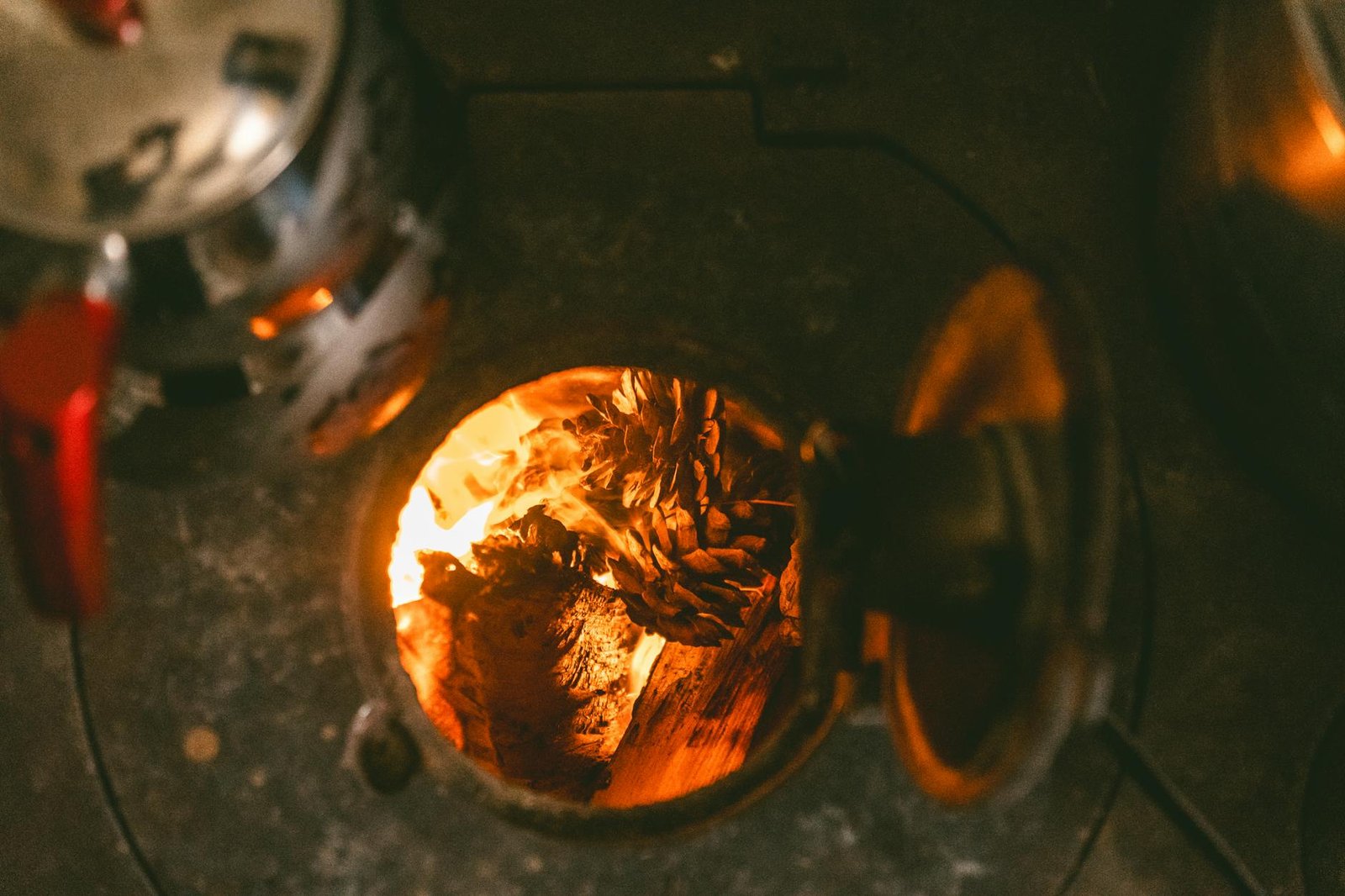 Gas Stove vs Electric Stove Heat Distribution What You Need to Know 2 A close-up of pinecones burning in a cozy fireplace, evoking warmth and comfort.