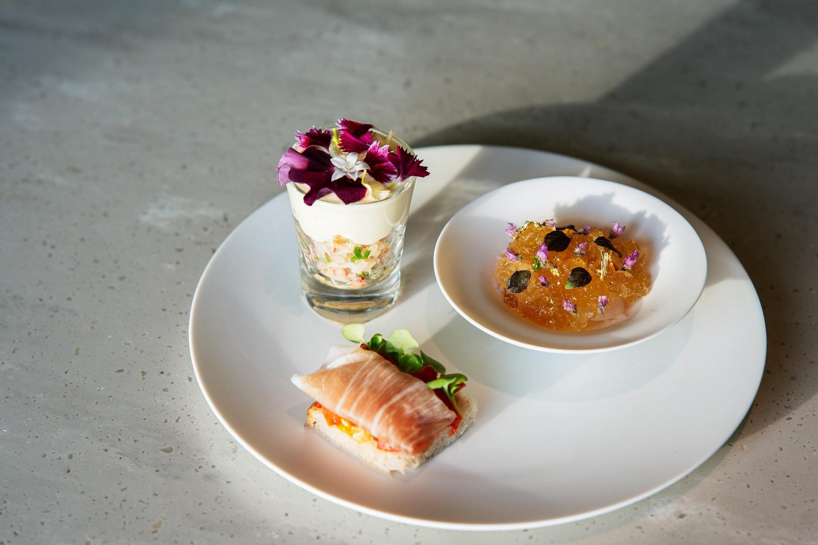 Sophisticated gourmet dessert arranged artistically on a white plate with floral accents.