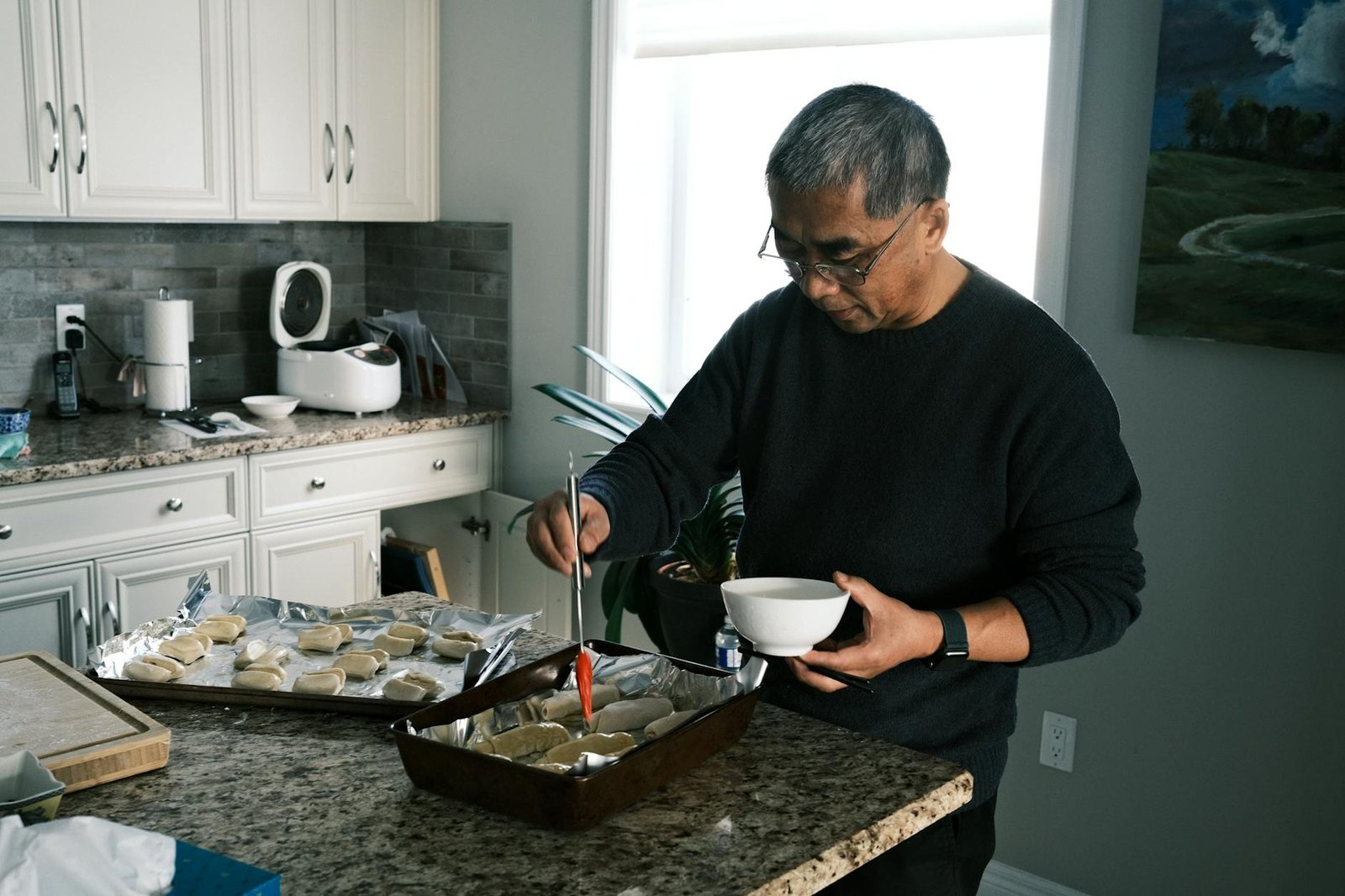 Senior man preparing food at kitchen counter, focused and immersed in cooking.