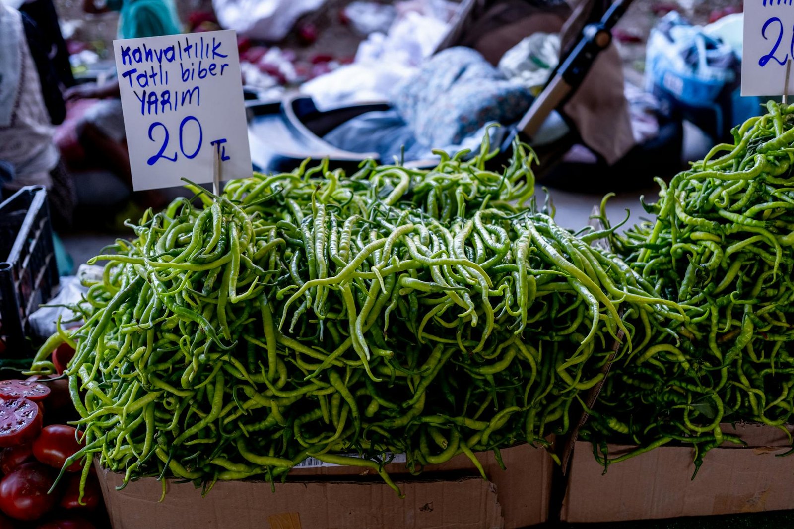 Fresh green peppers on display at a local market, labeled with price in Turkish Lira.