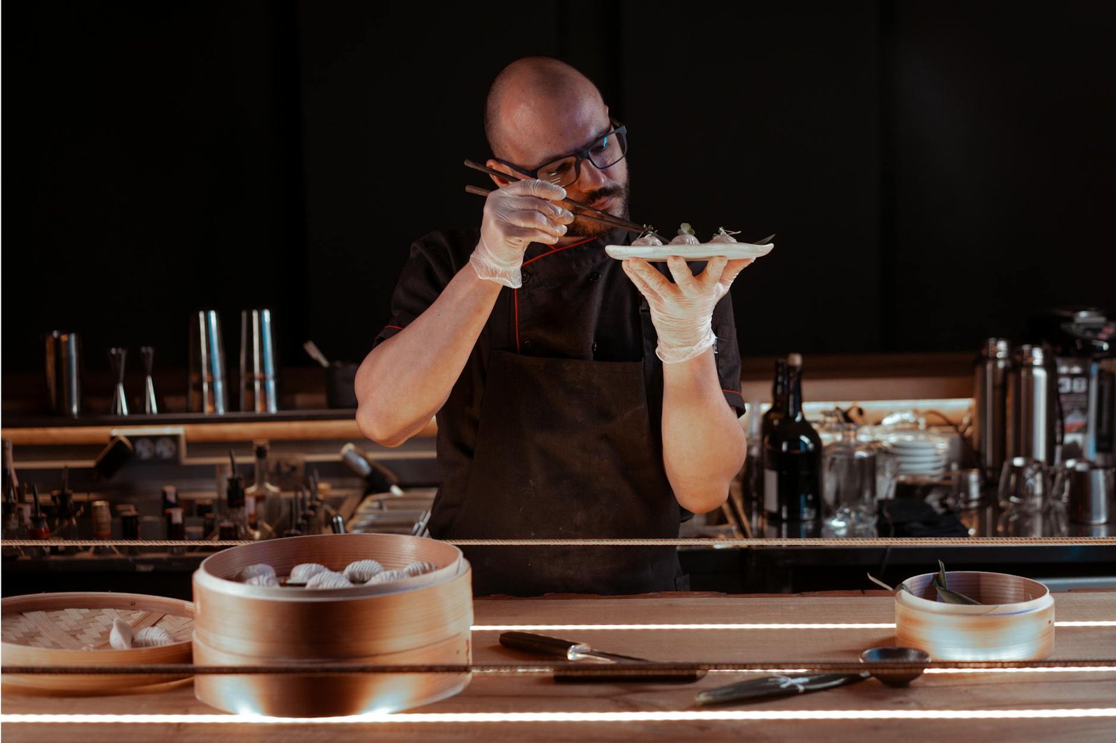 A chef expertly prepares dumplings in a cozy restaurant setting, focusing on detail.