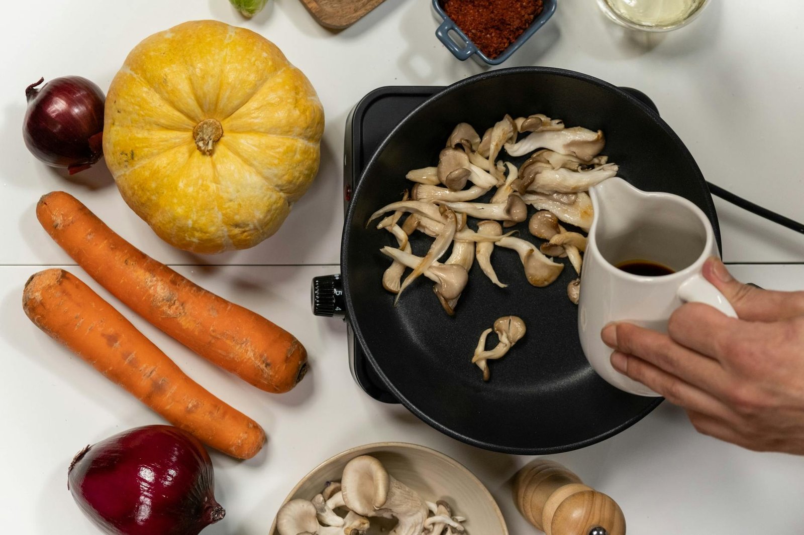 Stainless Steel vs Non-Stick Pans for Induction Cooking: A First-Timer's Guide 2 Top view of cooking mushrooms with autumn vegetables for a flavorful dish.