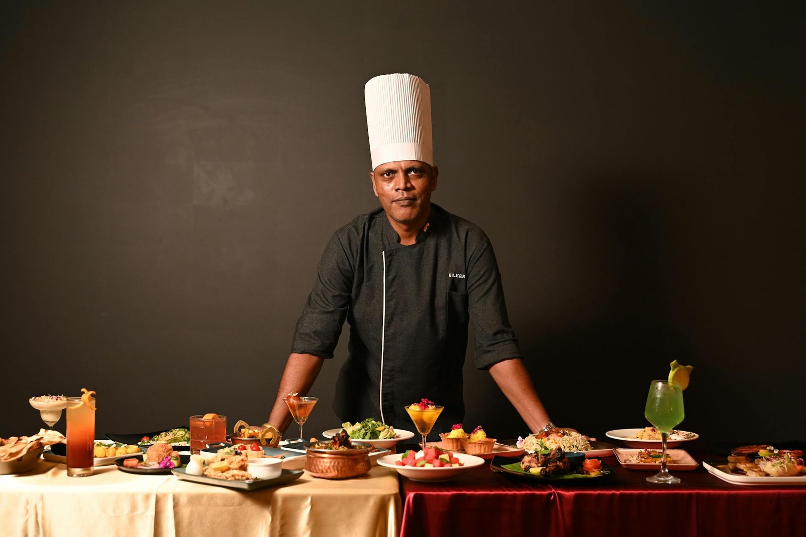 A skilled chef in Goa showcasing an array of gourmet dishes, highlighting Indian and fusion cuisine.